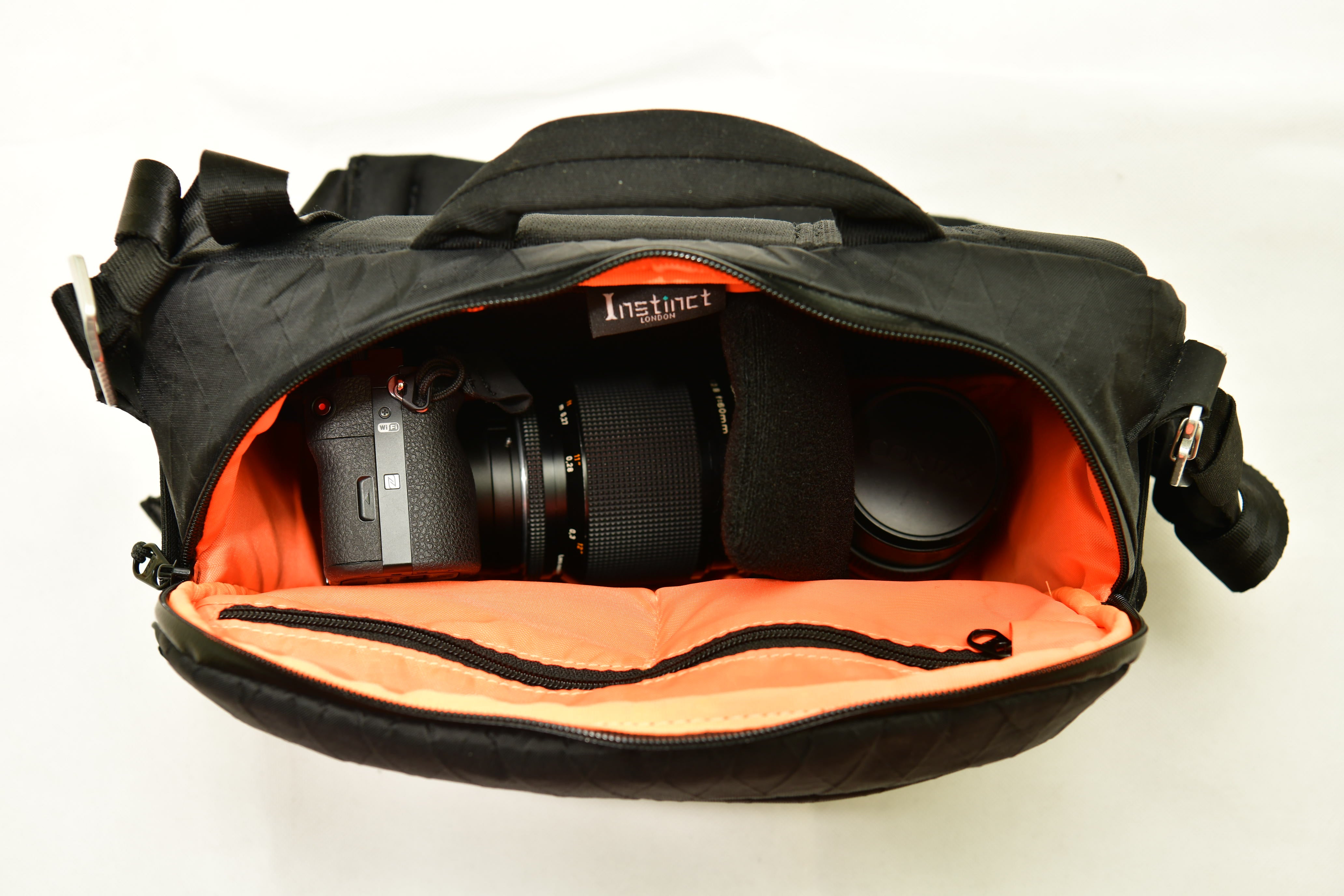 Sony A7 camera with Contax 2.8 60mm lens and Contax 2.8-22 55mm lens inside black x-Pac camera sling bag 7L with orange internal lining