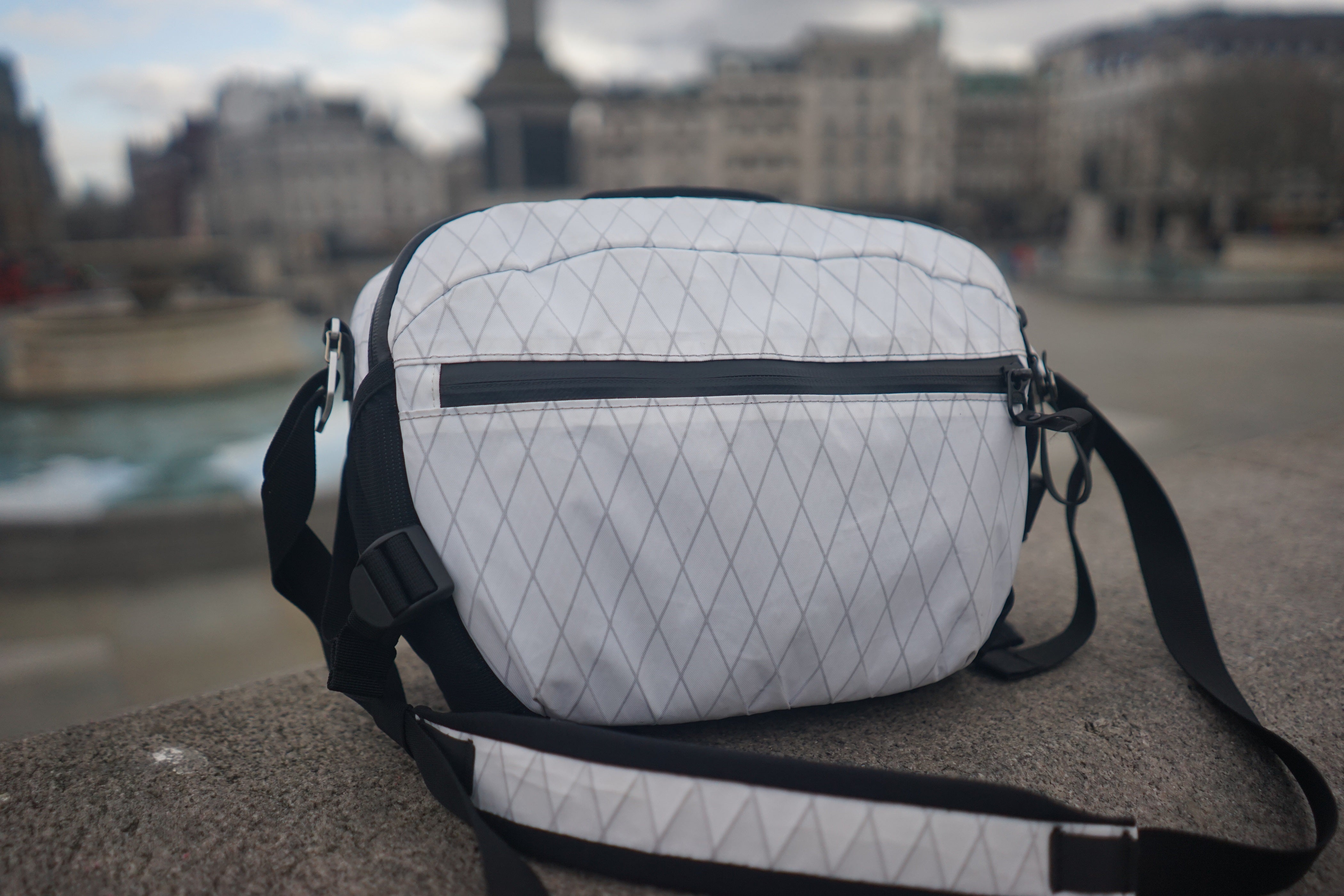 white camera sling bag at city 